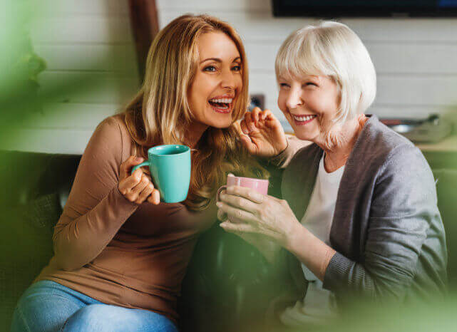 caregiver and elderly woman drinking coffee