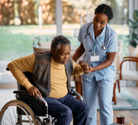 nurse helping the elderly man get up