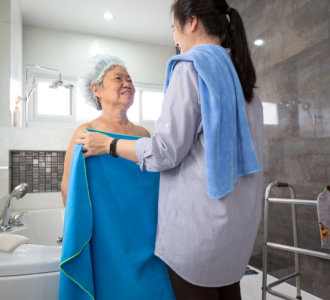 caregiver putting a towel on the senior woman