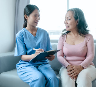 senior woman and caregiver holding a clipboard