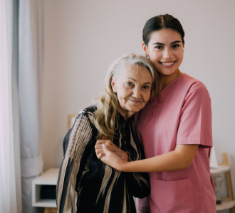 caregiver embracing the elderly woman