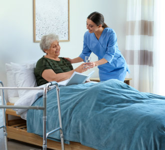 caregiver giving water to the elderly woman