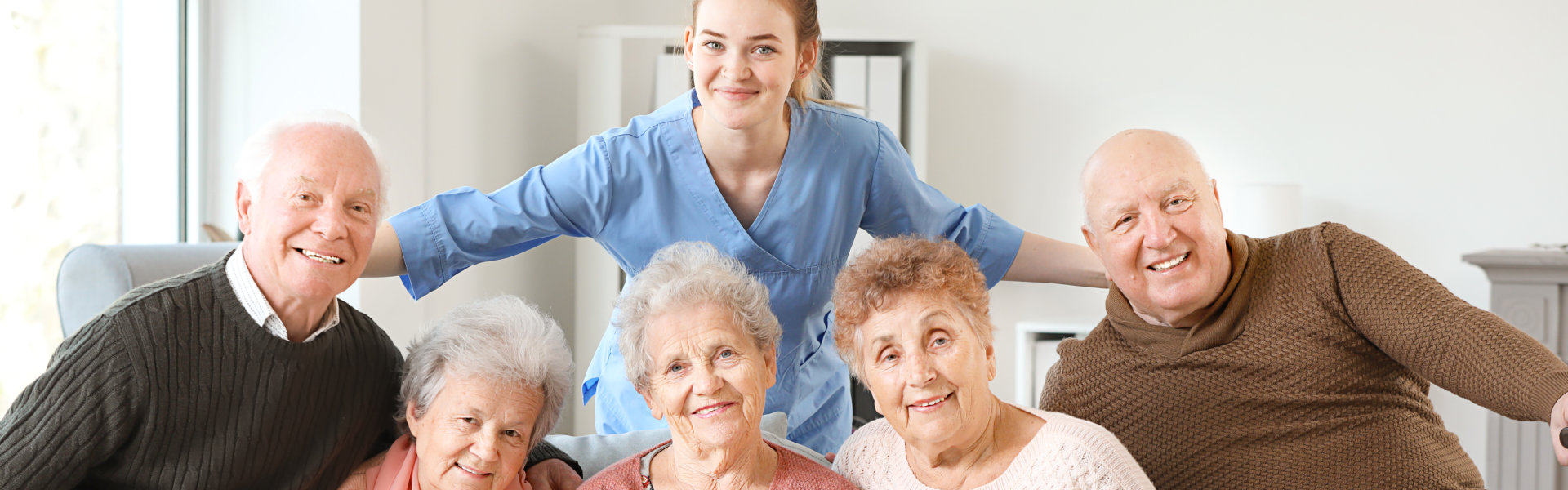 caregiver and elderly men and women smiling