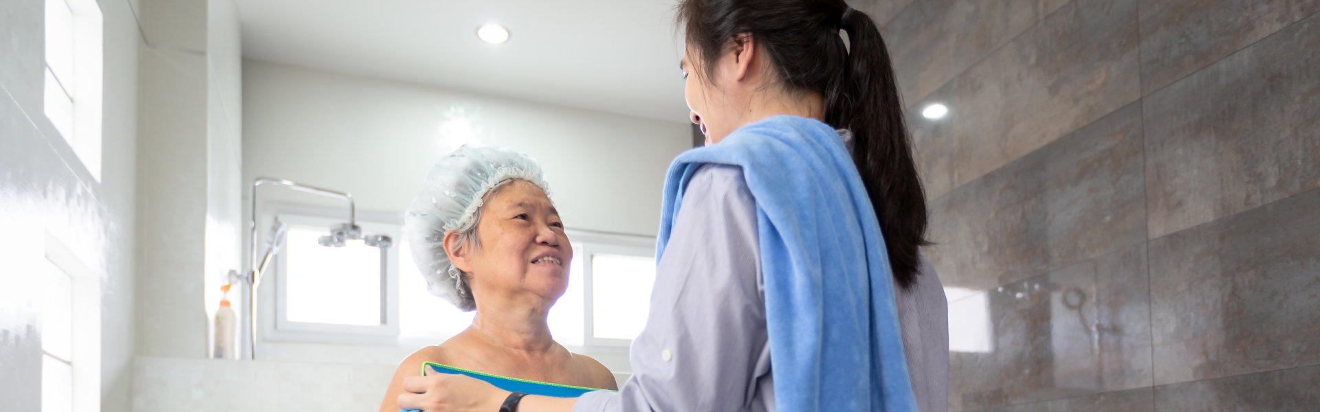 caregiver putting a towel on the senior woman