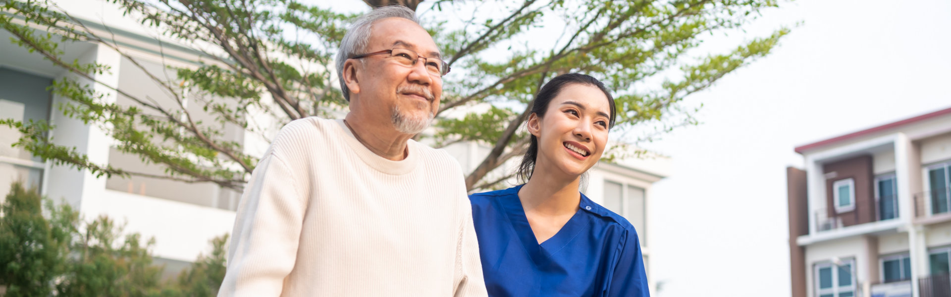 caregiver and elderly man walking outside