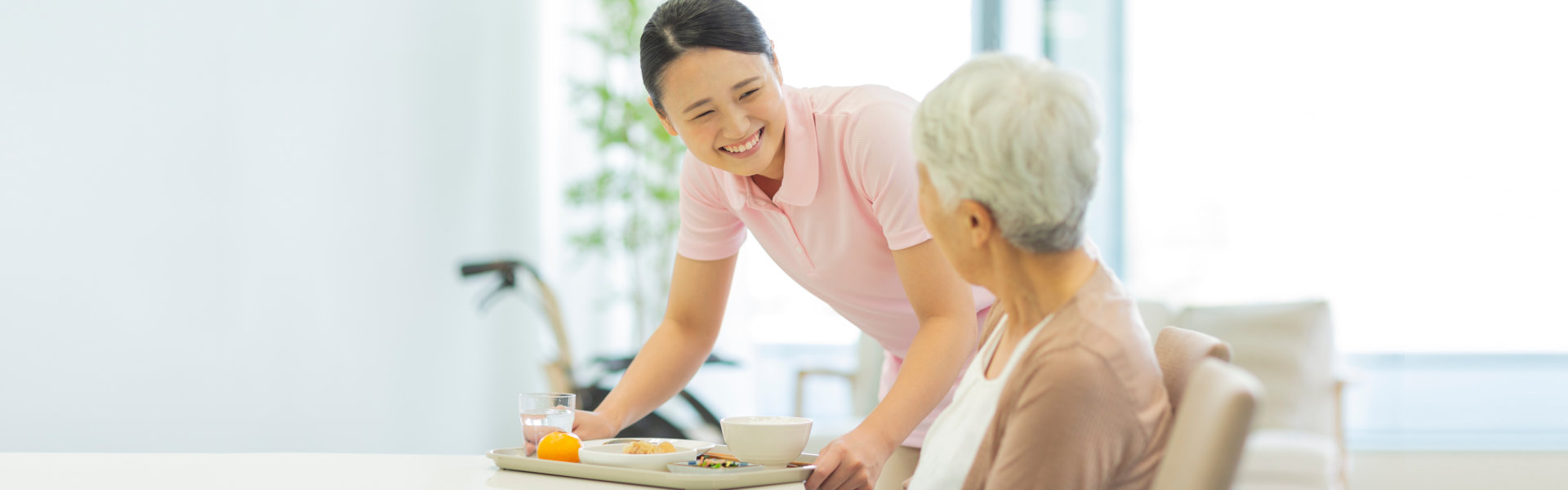 caregiver bringing food for the senior woman