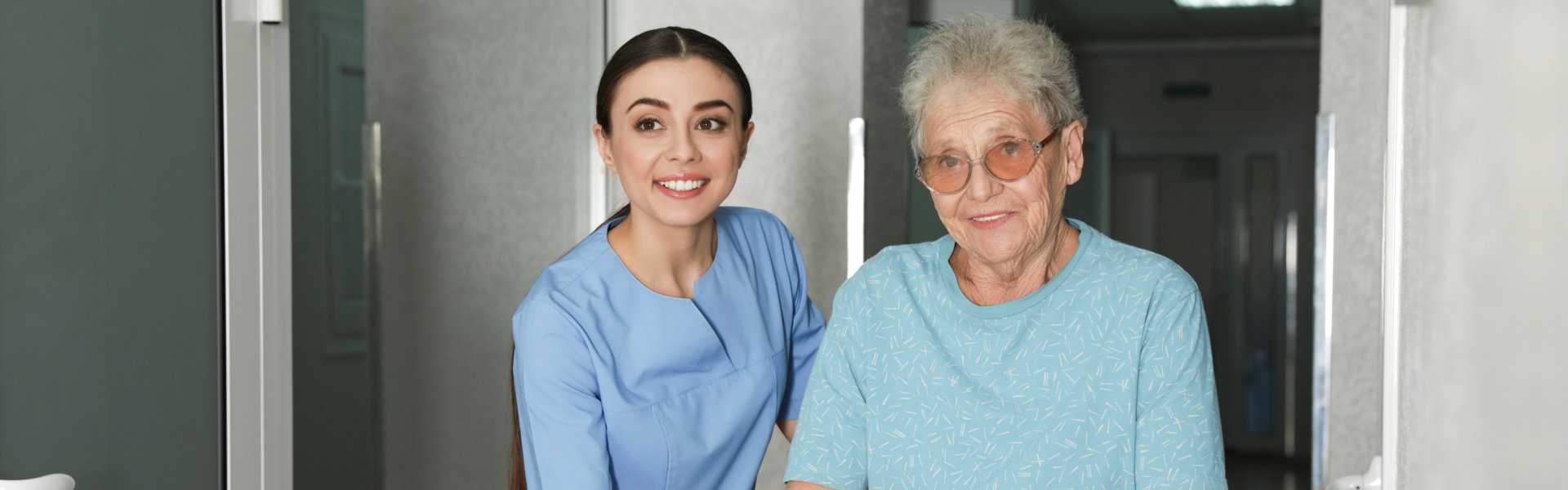 caregiver holding the elderly woman while walking