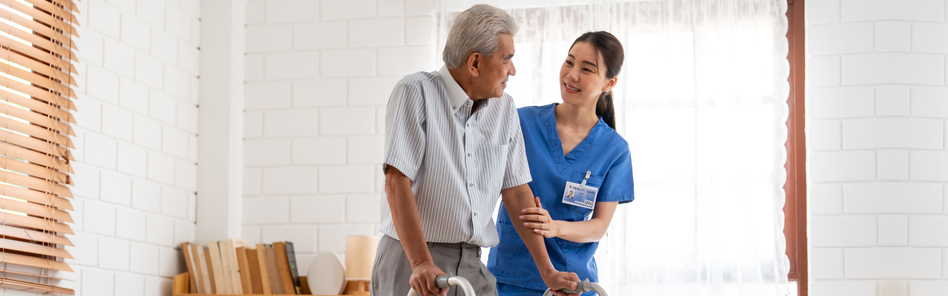 caregiver holding the senior man while walking