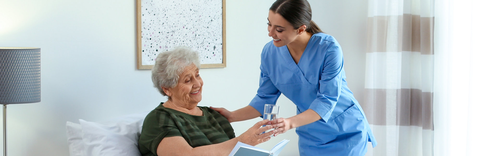 caregiver giving water to the elderly woman